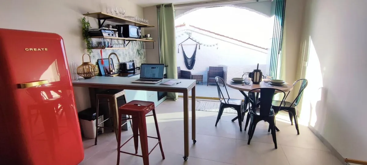 Kitchen with red retro fridge, desk and dining table