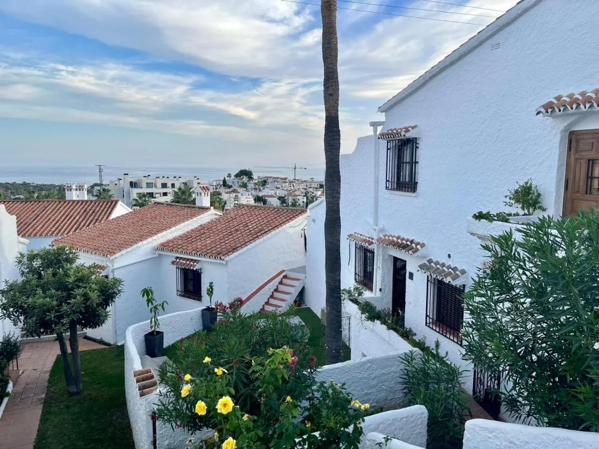 Whitewashed lane of Capistrano Village with the sea behind